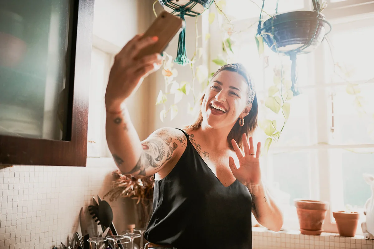 young woman using a smartphone in the kitchen at home