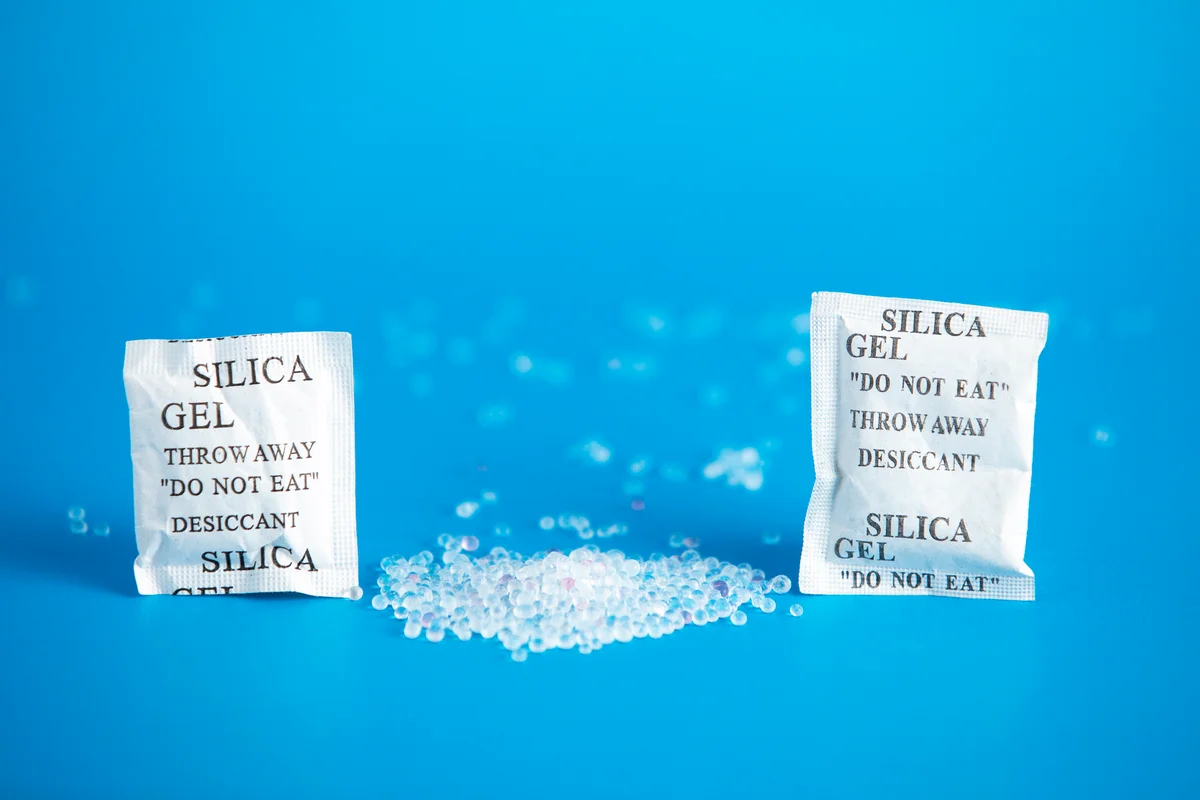 Desiccant or silica gel indifferent packaging and spread on blue background