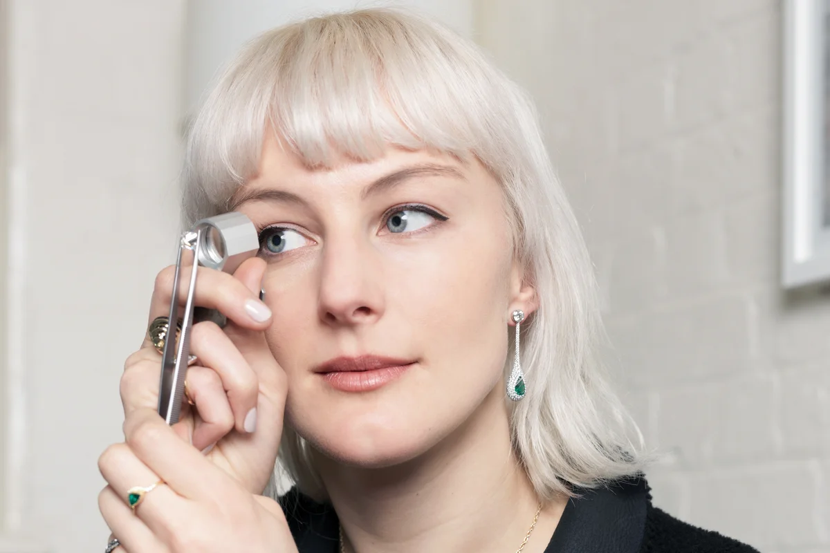 Jeweler examining diamond using magnifier in jewellery shop