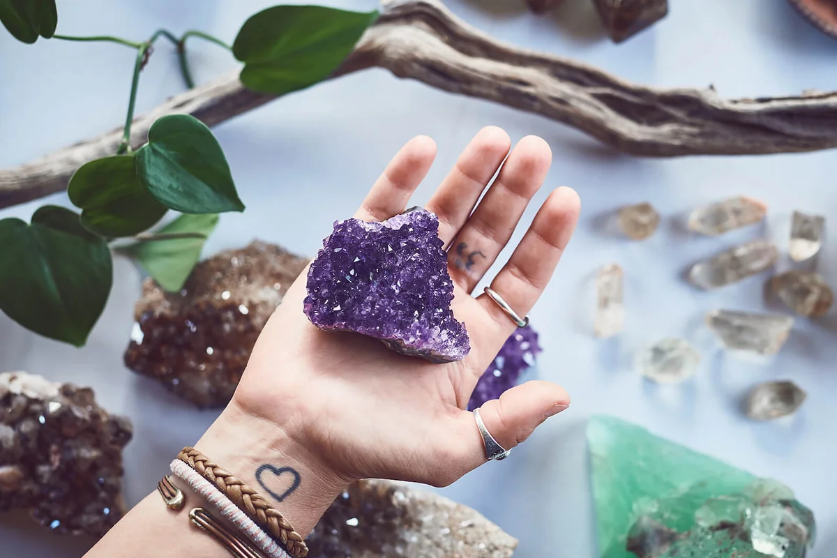 a person holding a crystal with hand over a table