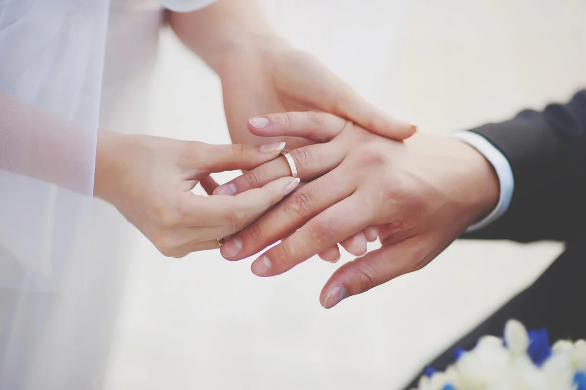 Midsection Of Couple Exchanging Wedding Ring