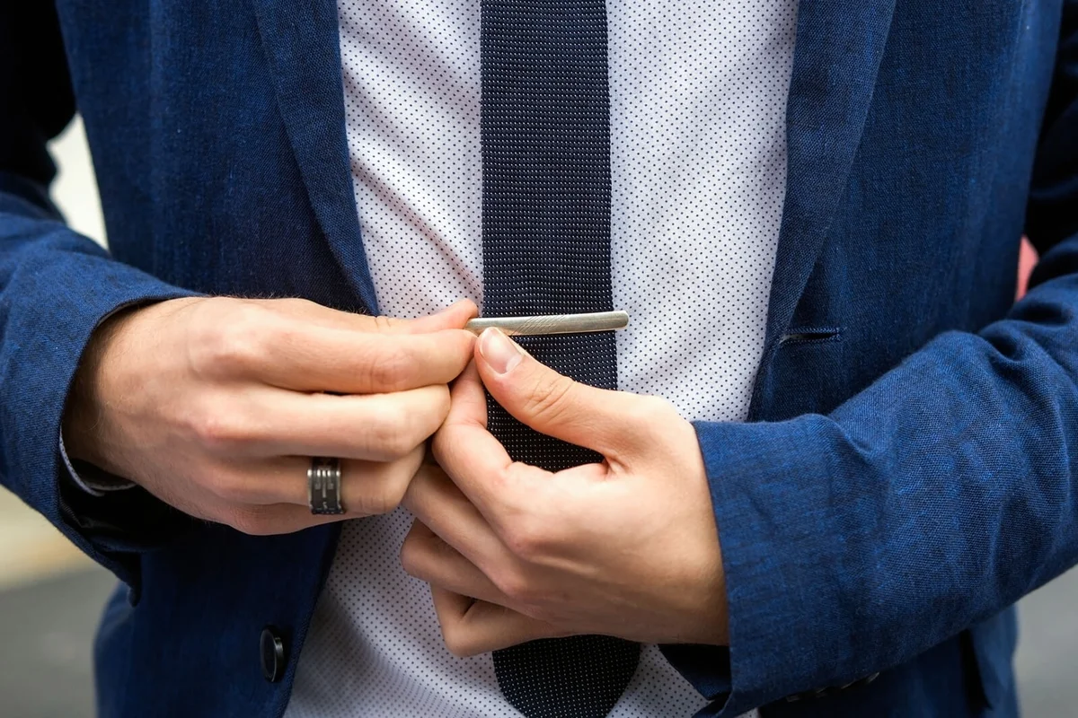 Young teen boy casually dressed fixes his tie needle