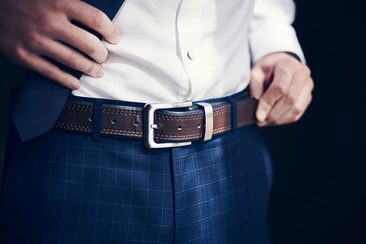 man wearing a belt with his jeans and shirt on his wedding day