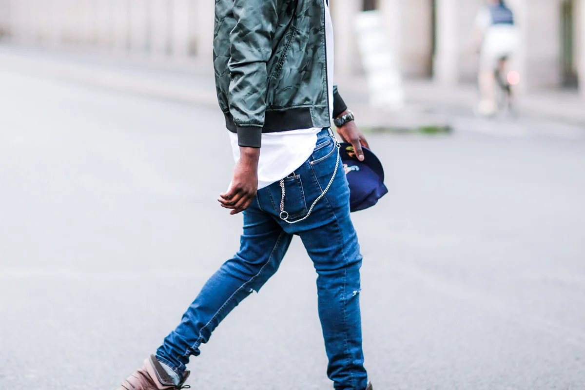 Sidya Sarr is wearing a green Asos jacket, a Versace watch, Asos blue denim slim jeans, a Dashiki white shirt, an Asos wallet chain | Getty Editorial Use