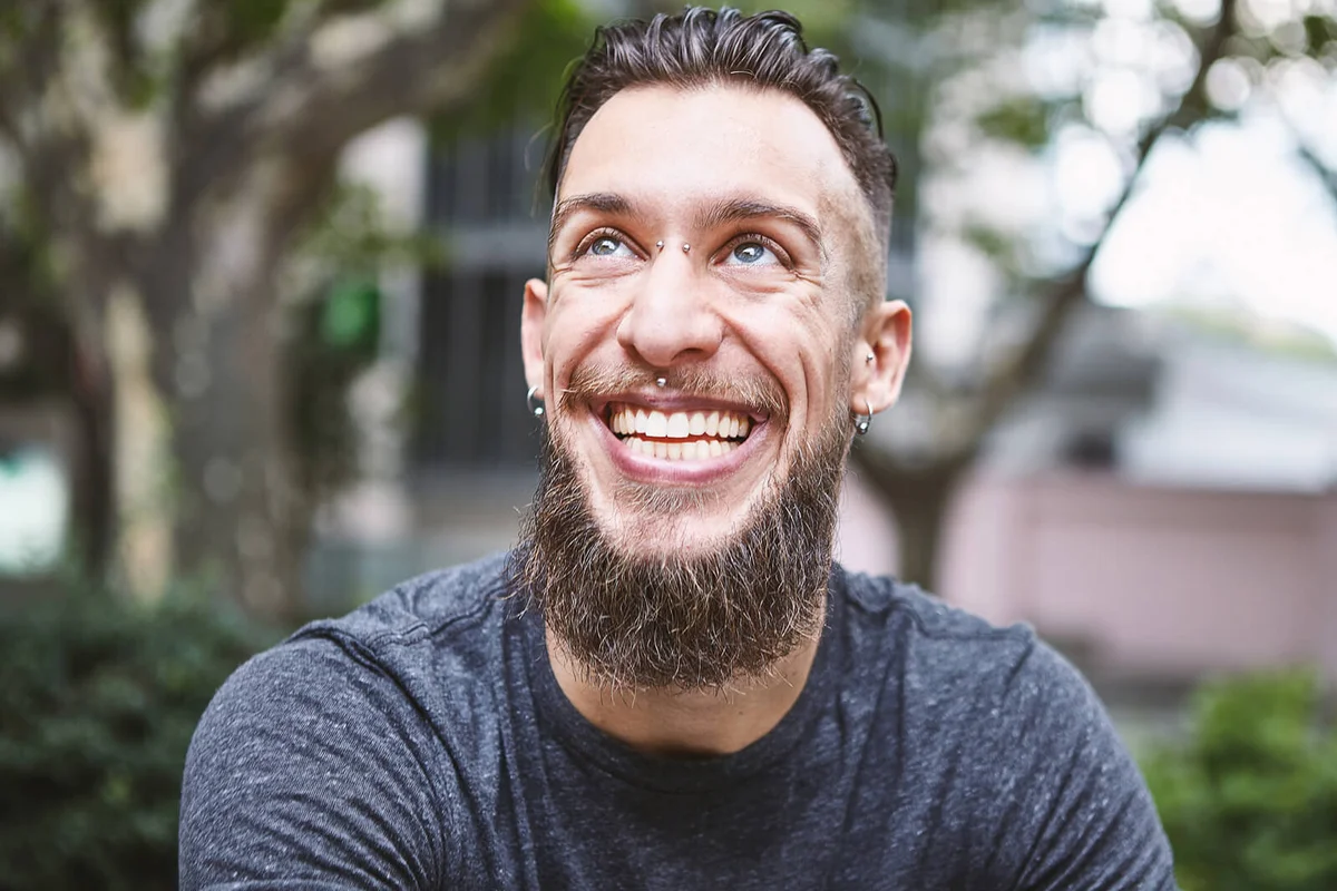 Happy young male hipster looking up