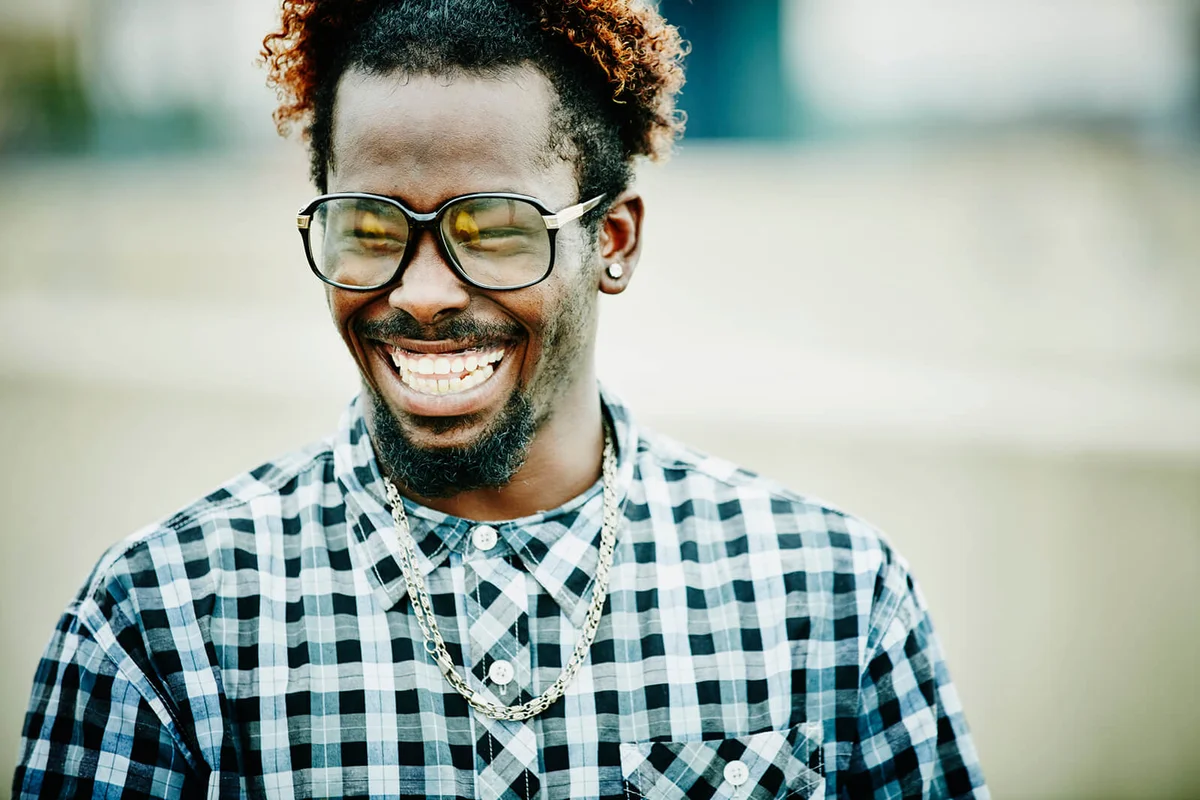 Laughing man in discussion with friends on rooftop