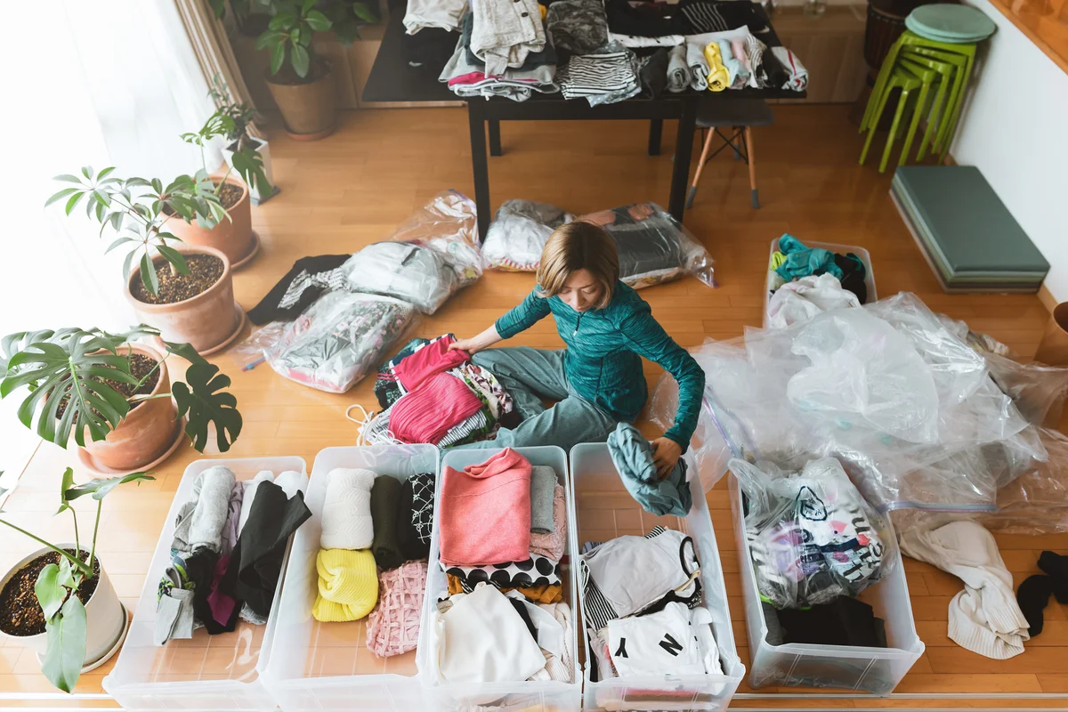 Woman organizes clothes in living room