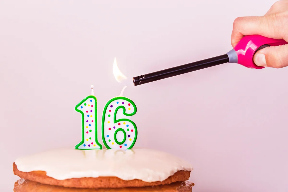 Hand Igniting Candle On Cake