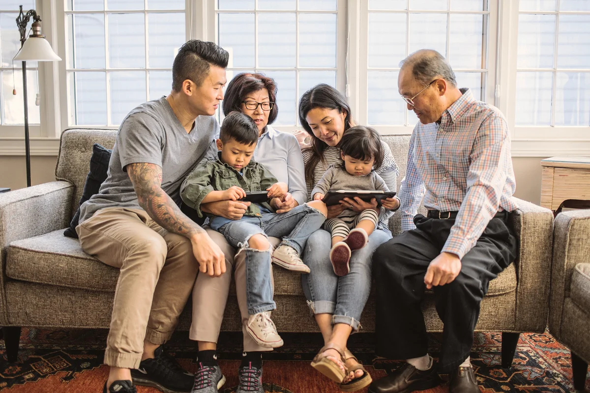 3 generations on couch looking at tablet