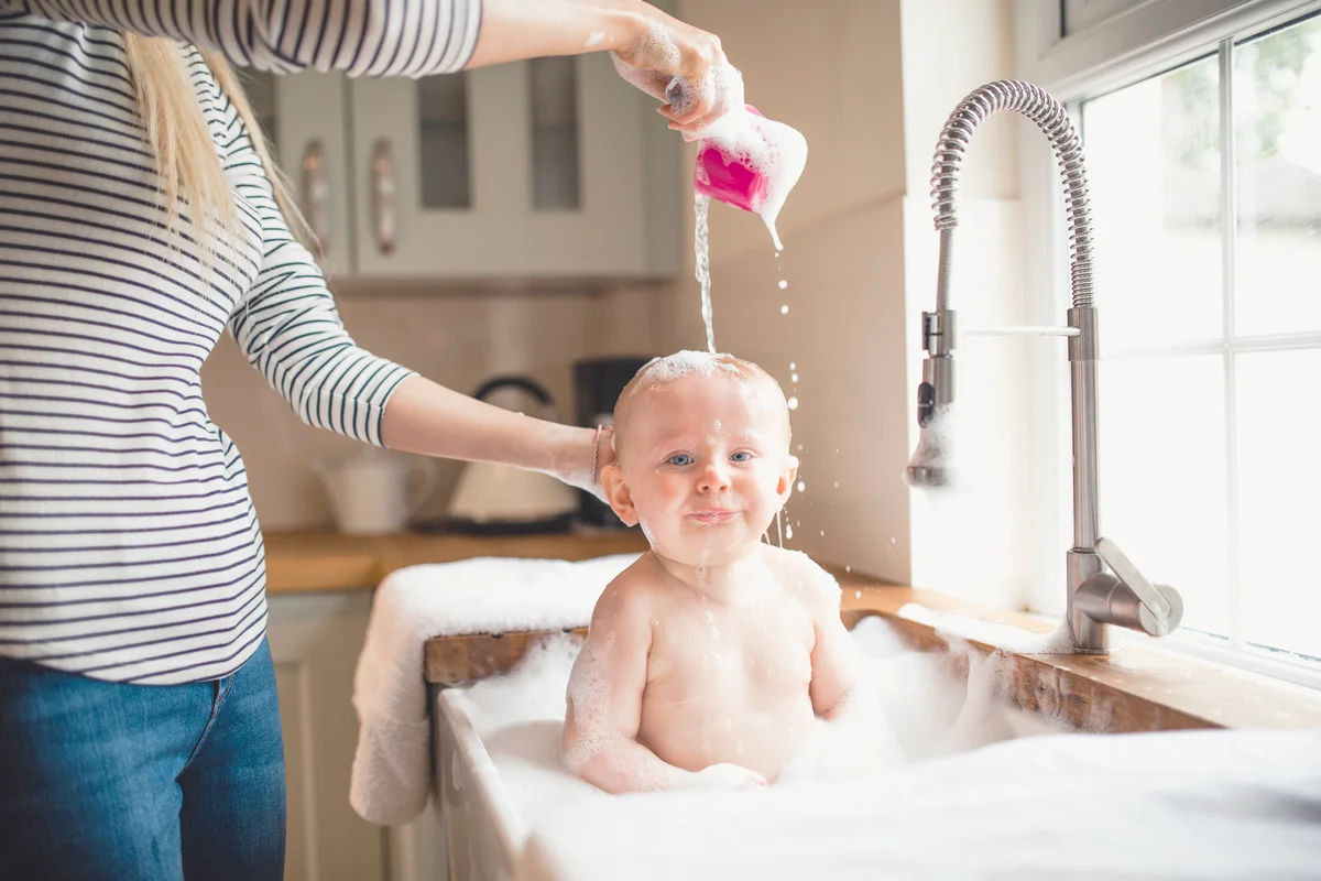 Mother Pours Water Over Babies Head