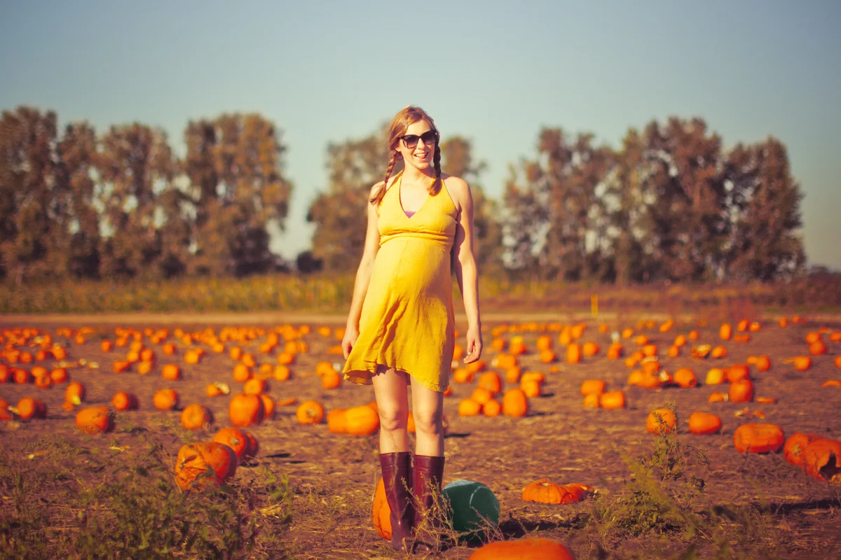 Pregnant woman in pumpkin field