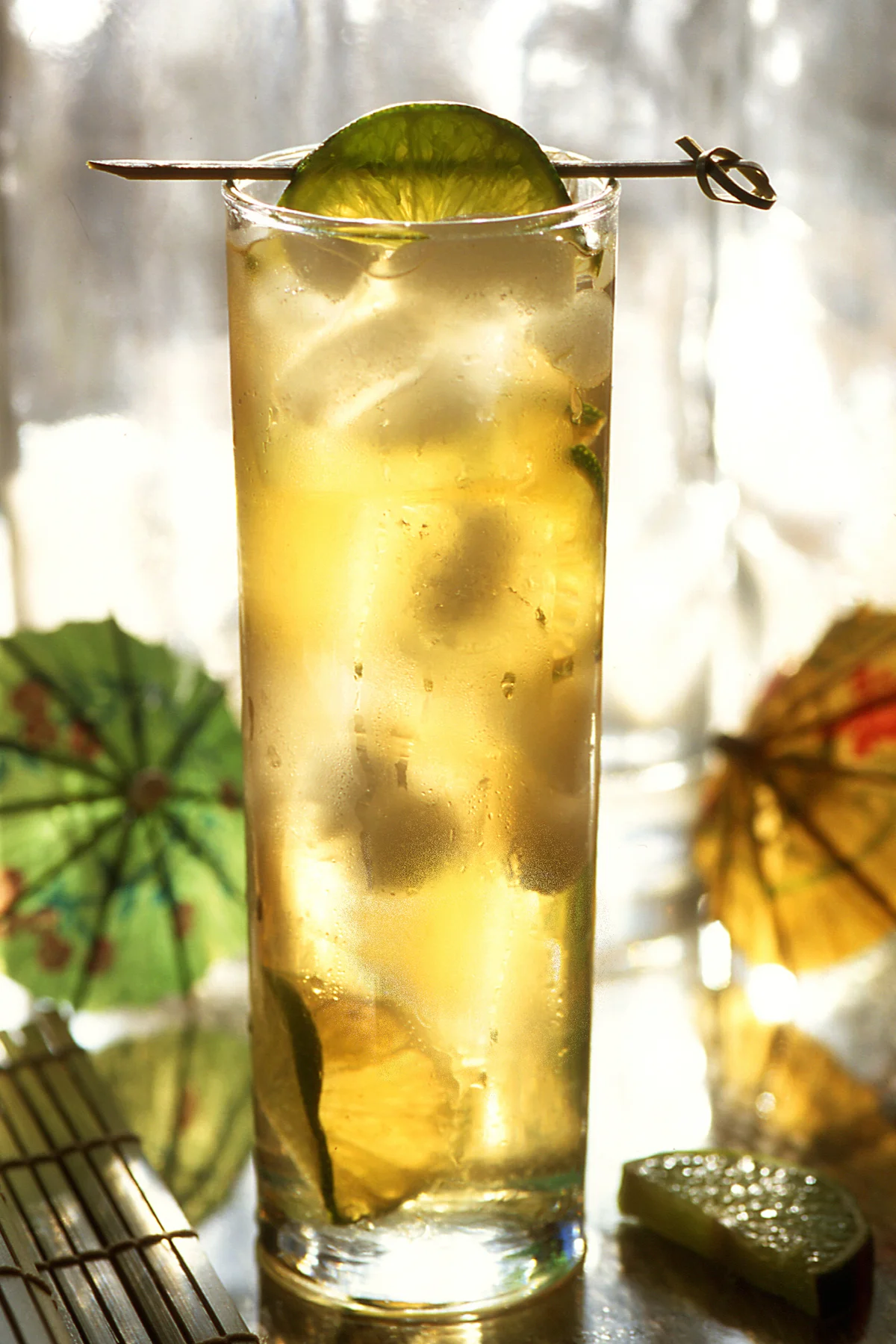 Cocktail with a fruit garnish in a colorful tropical setting