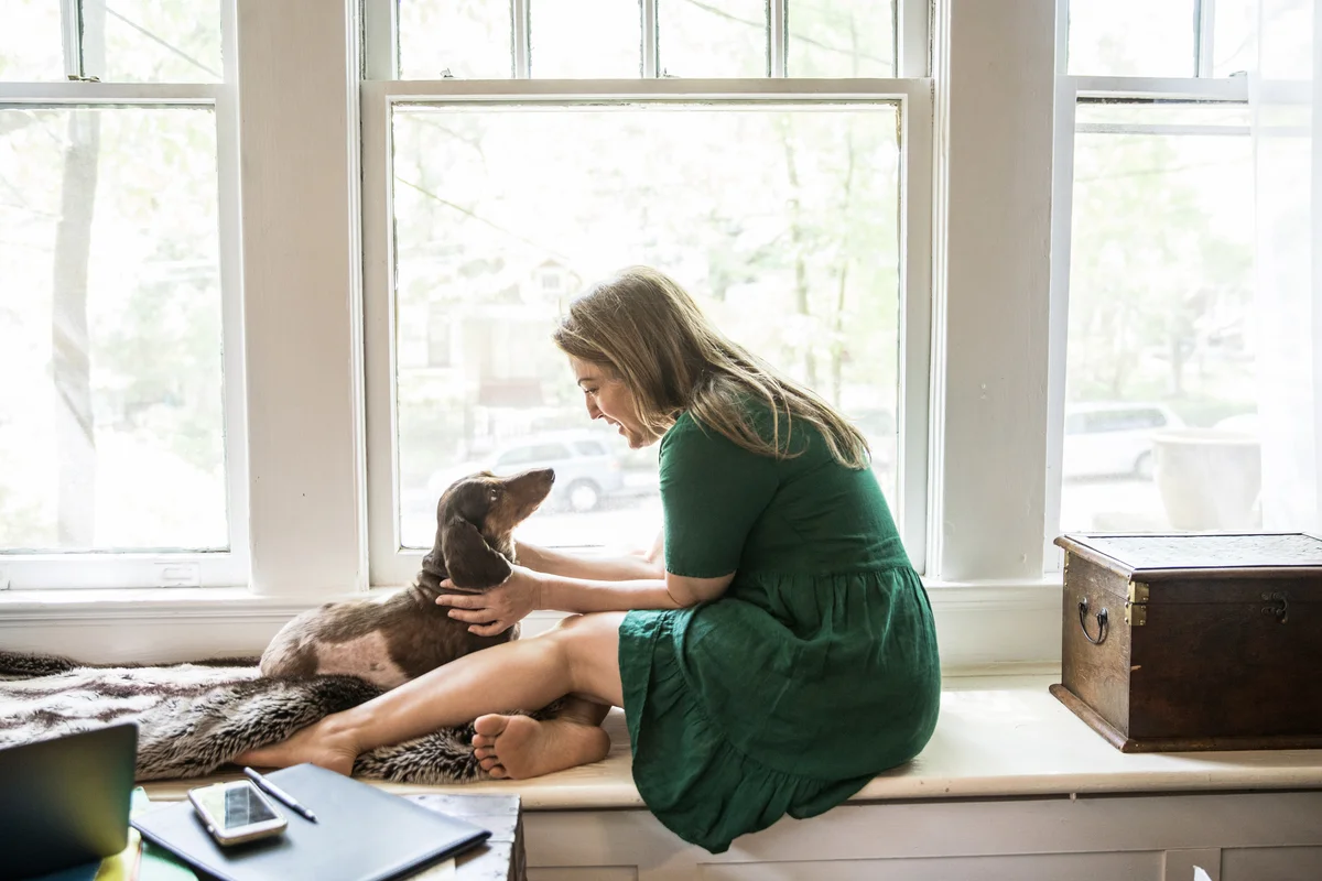 Woman sitting in window with dog