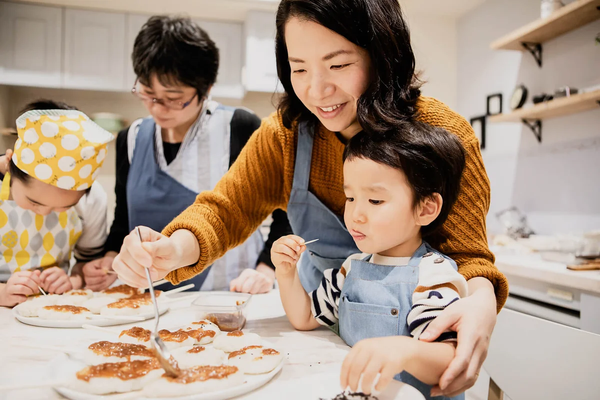Mother finishing food and son eating snacks