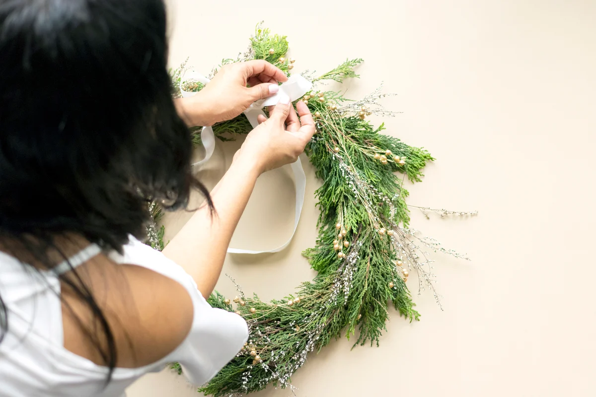 Woman decorates advent wreath with her hands