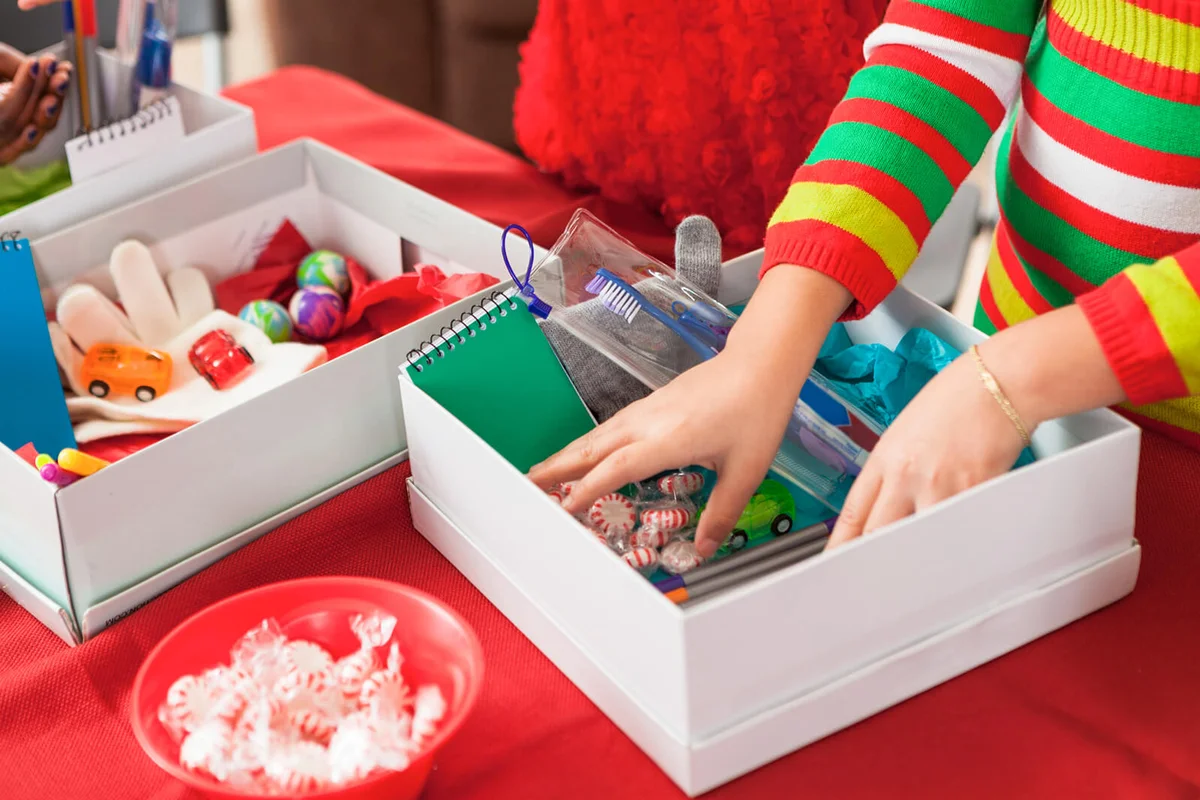 Female children filling holiday donation boxes for children in need