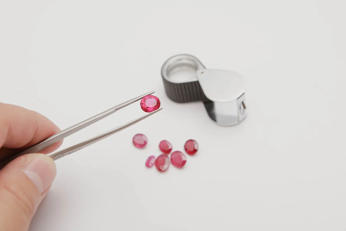 Person Holding Ruby With Tweezers