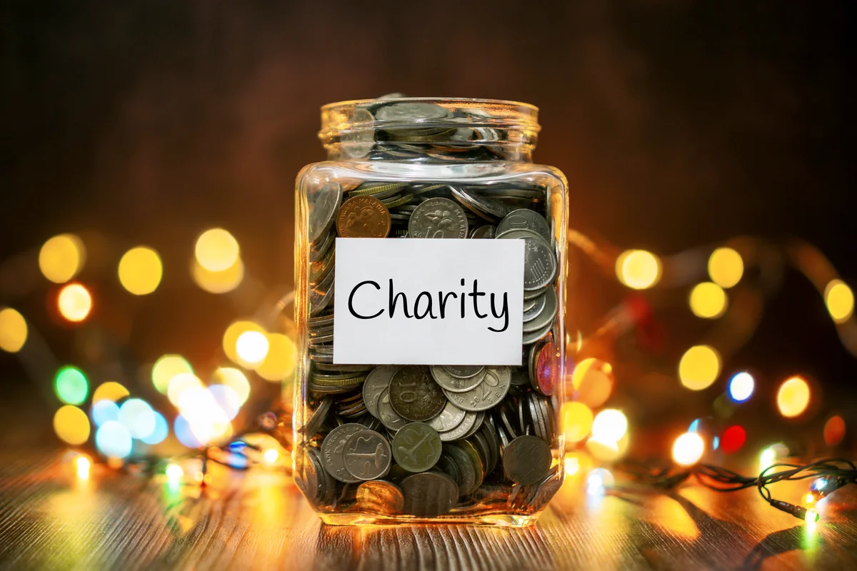 Jar of Coins for Charity Against Christmas Lights