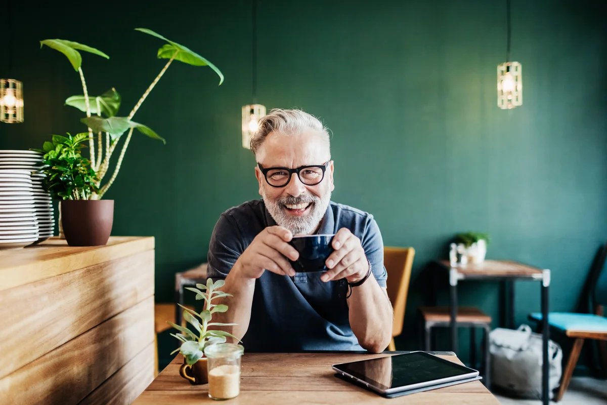 Cafe Customer Smiling While Drinking Coffee