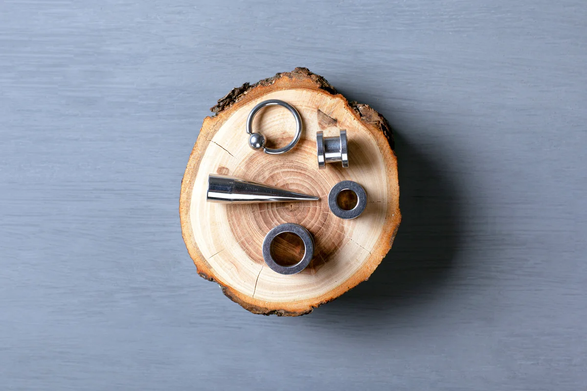 Earrings and stretch marks for piercing on a piece of wood