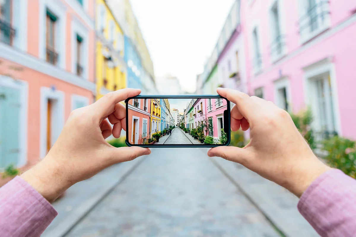 Personal perspective of a man photographing colorful street