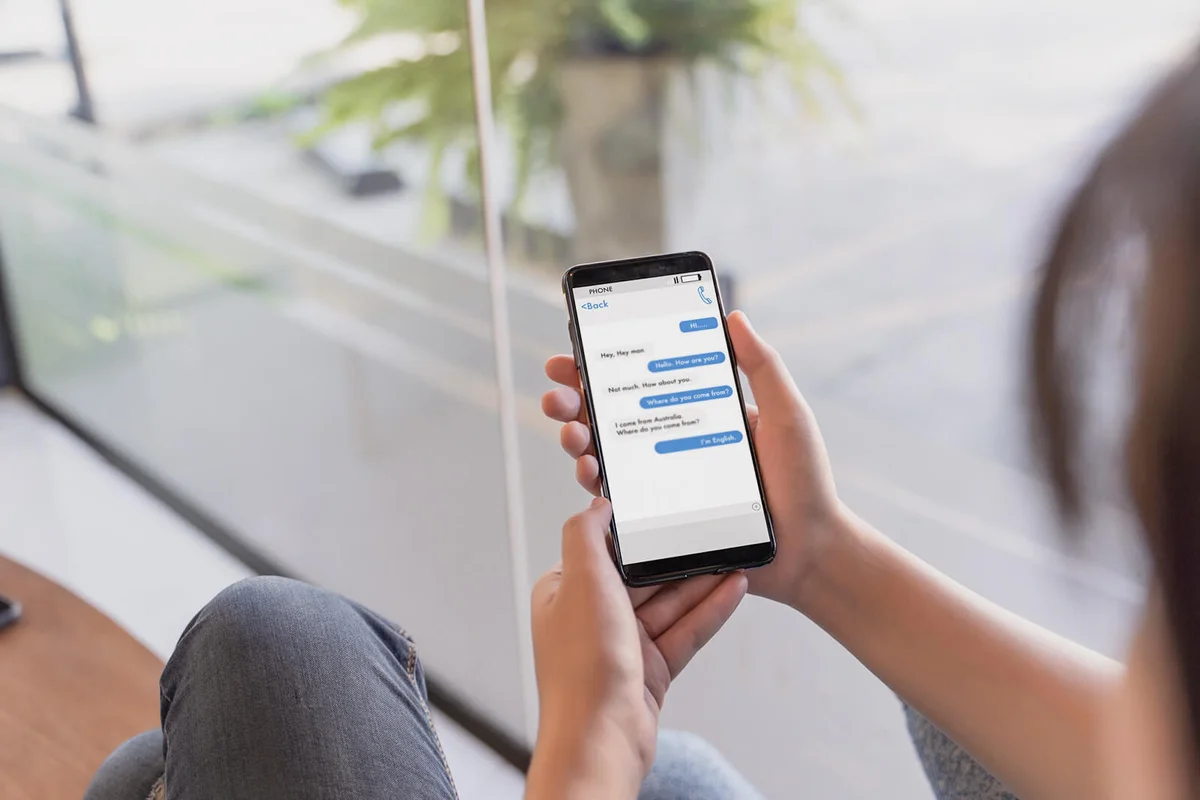 Woman Text Messaging Using Mobile Phone At Home