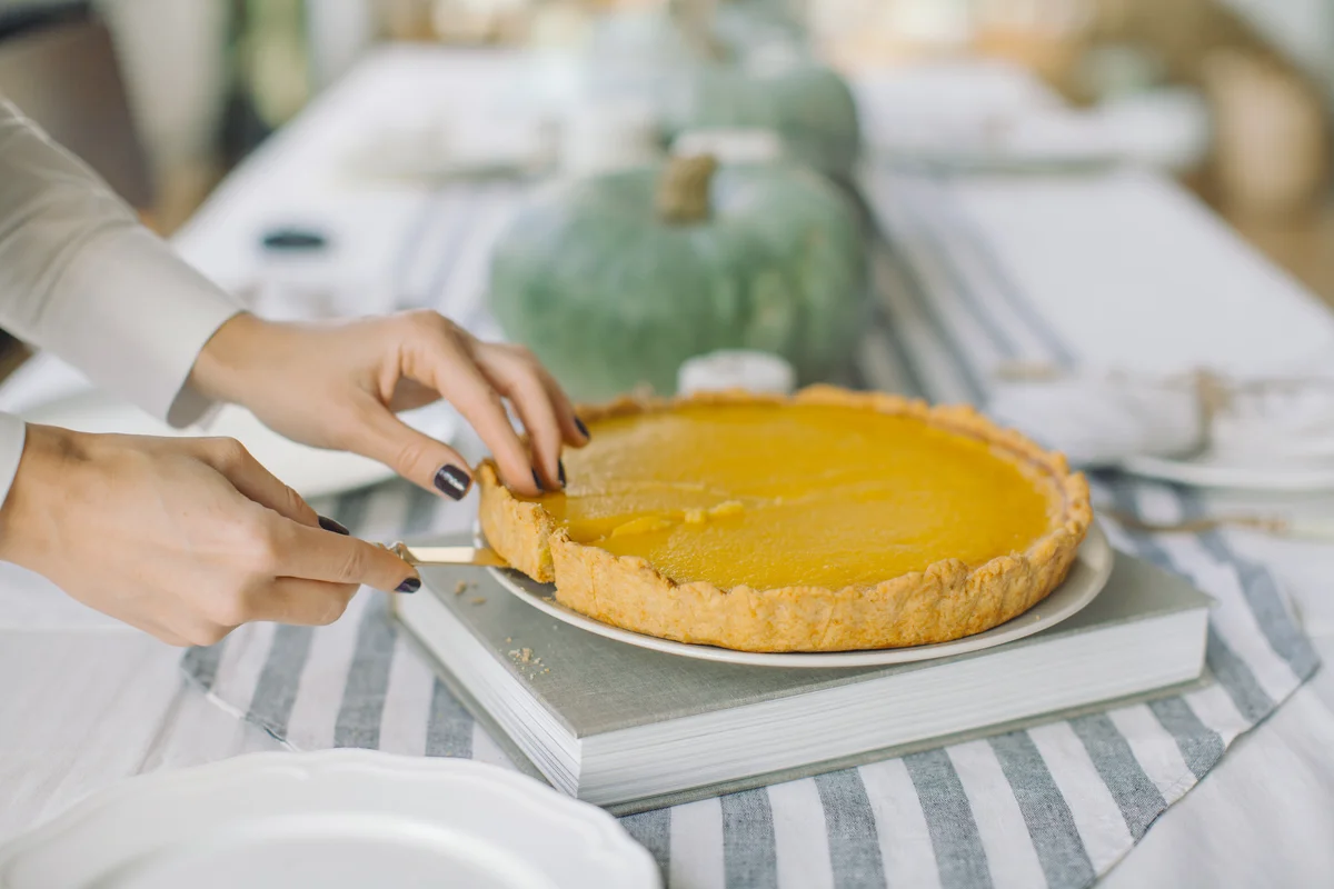 Woman Cutting Pie On Table