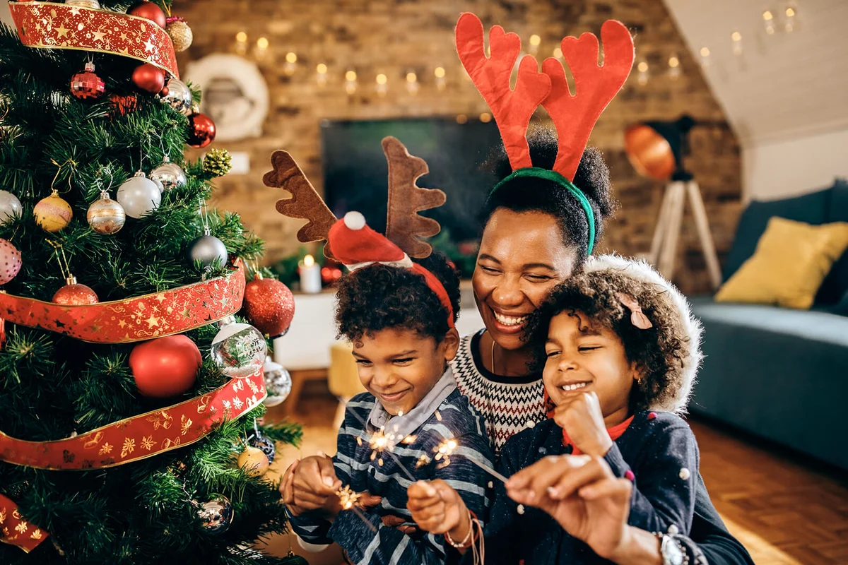 Joyful family celebrating Christmas and having fun with sparklers at home