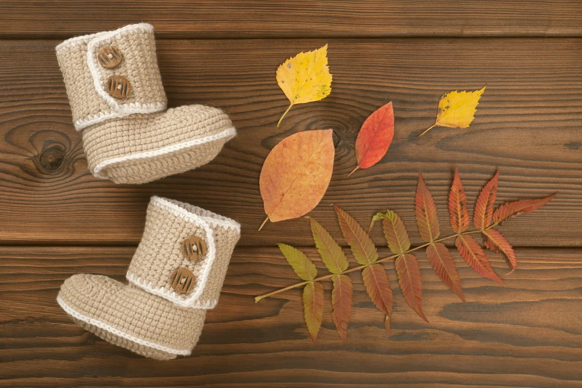 Hand made crochet baby booties and Autumn fallen multi-colored leaves