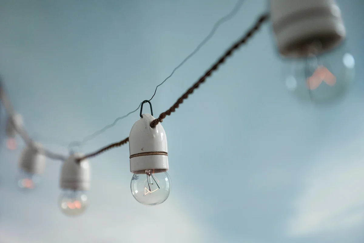 Low Angle View Of Light Bulb Hanging Against Sky