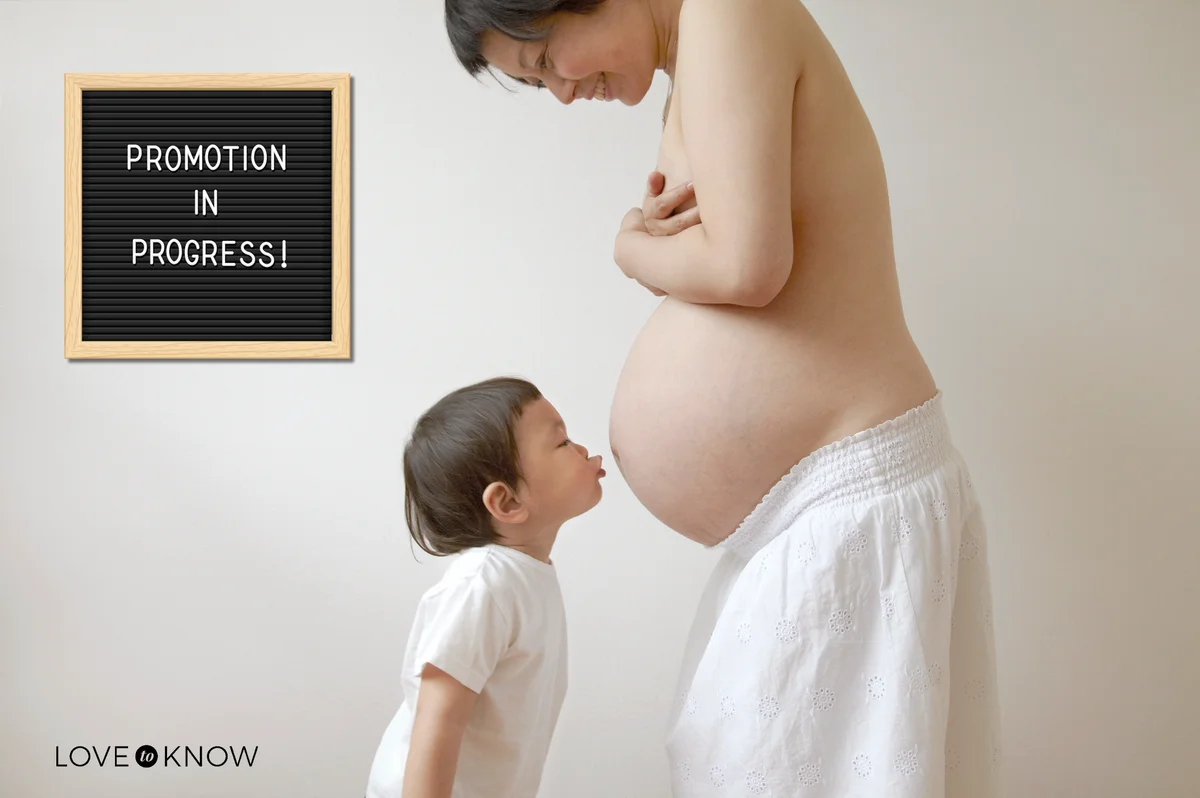 Child tries to kiss the belly of pregnant women