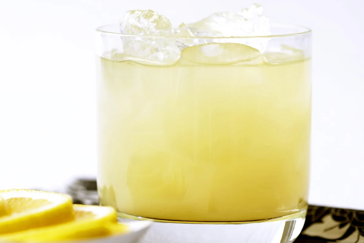 Pineapple juice with tequila and ice in glass