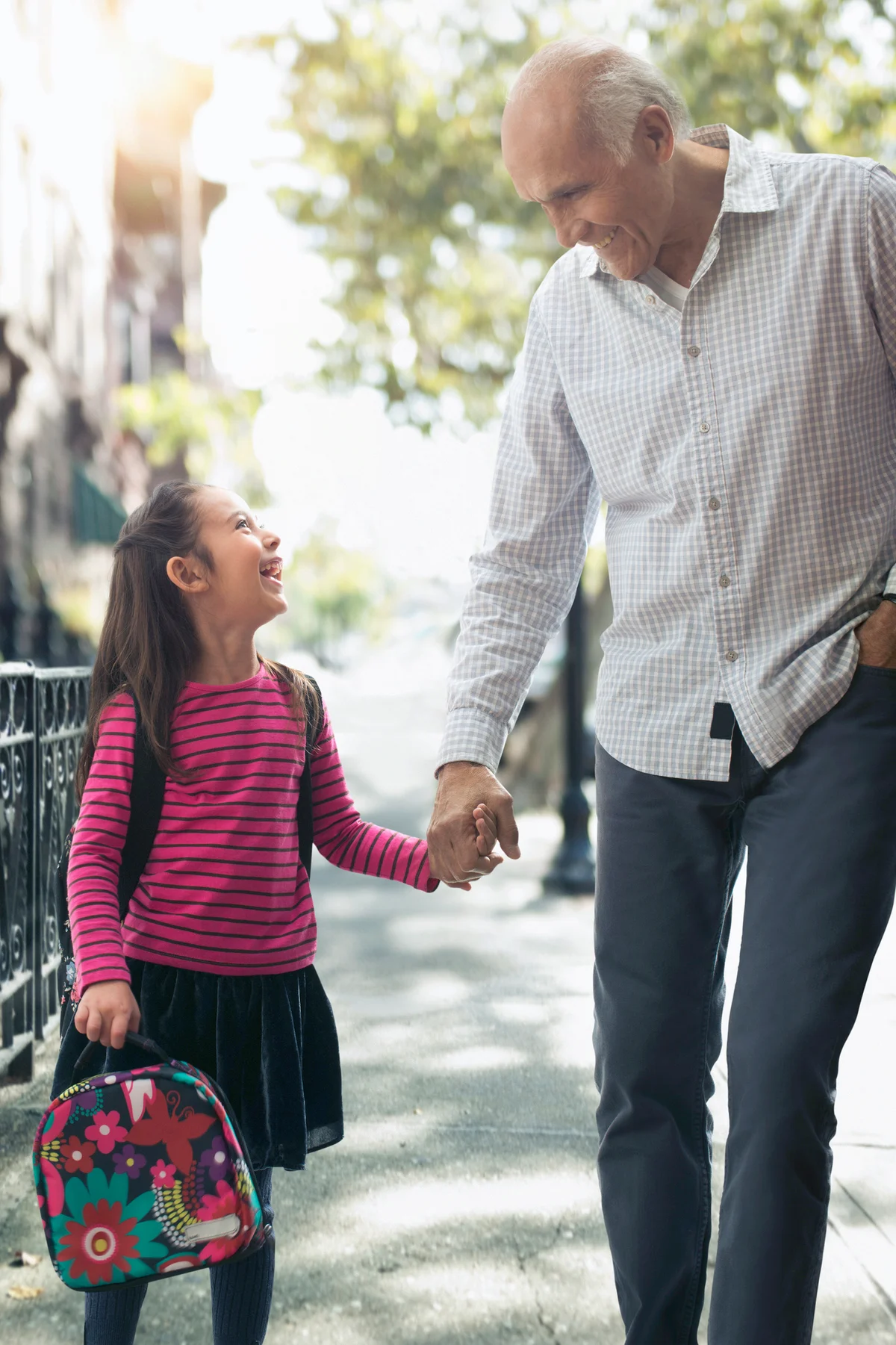 Grandfather walking granddaughter to school
