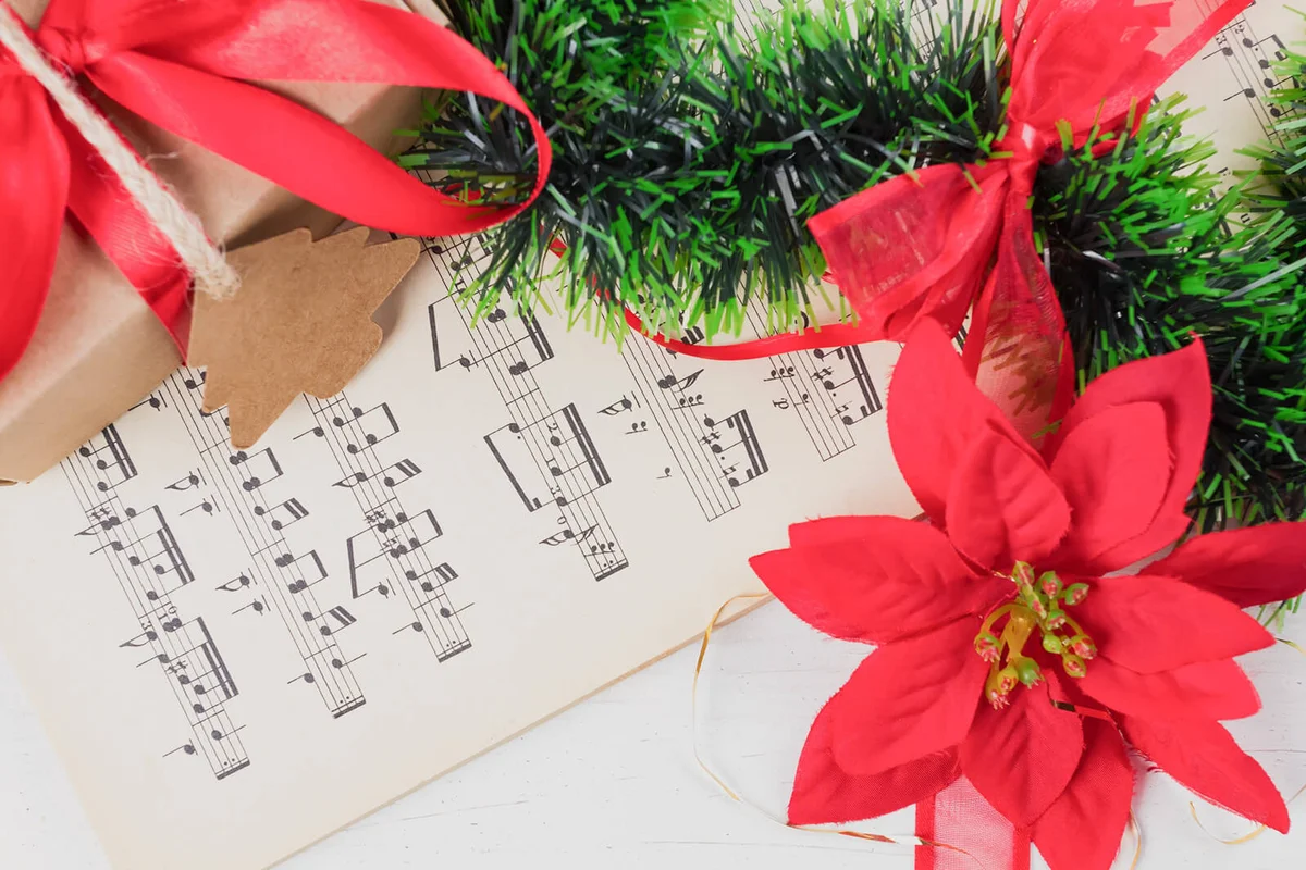 Christmas ornament and music sheet on white natural wooden table
