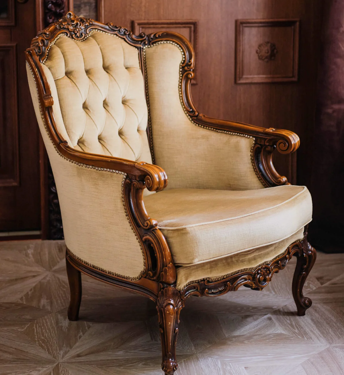 room is designed in English style with a beige velour chair