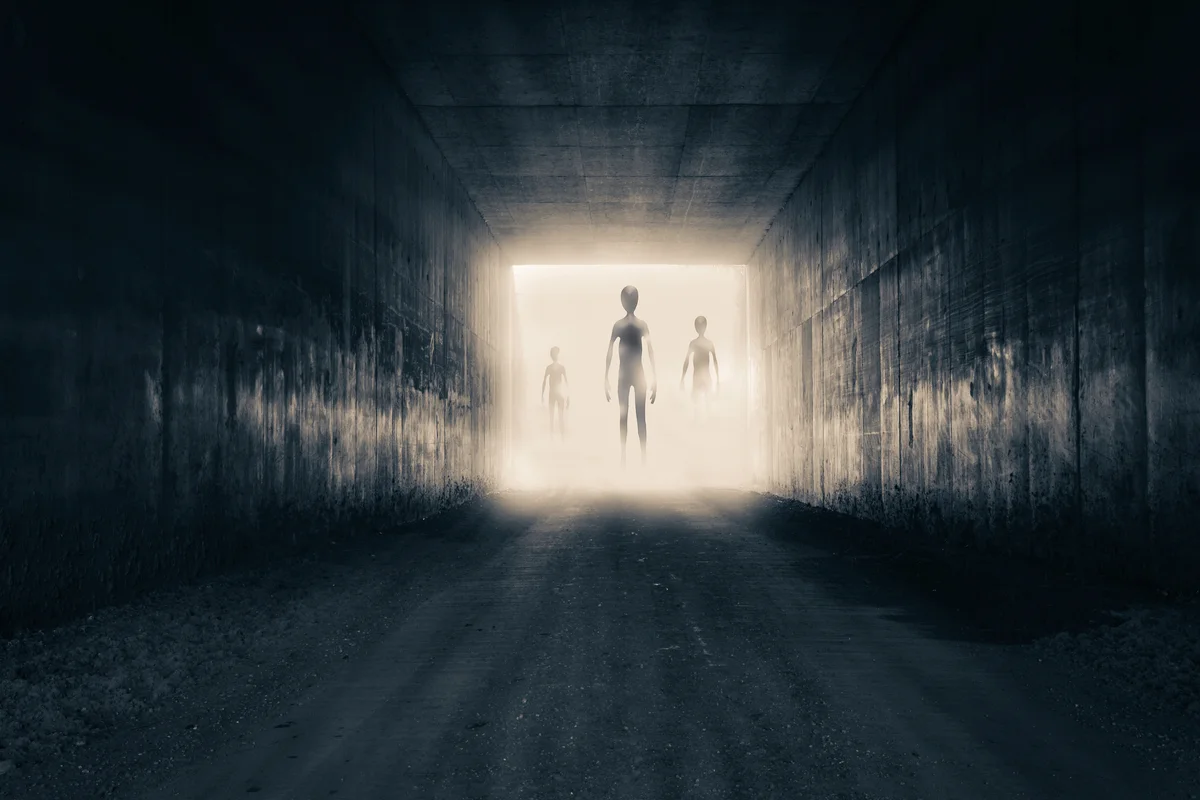 Aliens emerging from the light at the end of a dark sinister tunnel