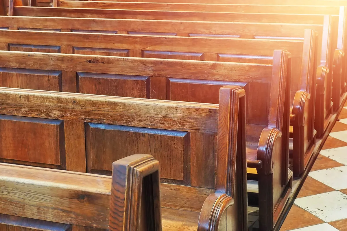 row of old wooden chair benches inside church