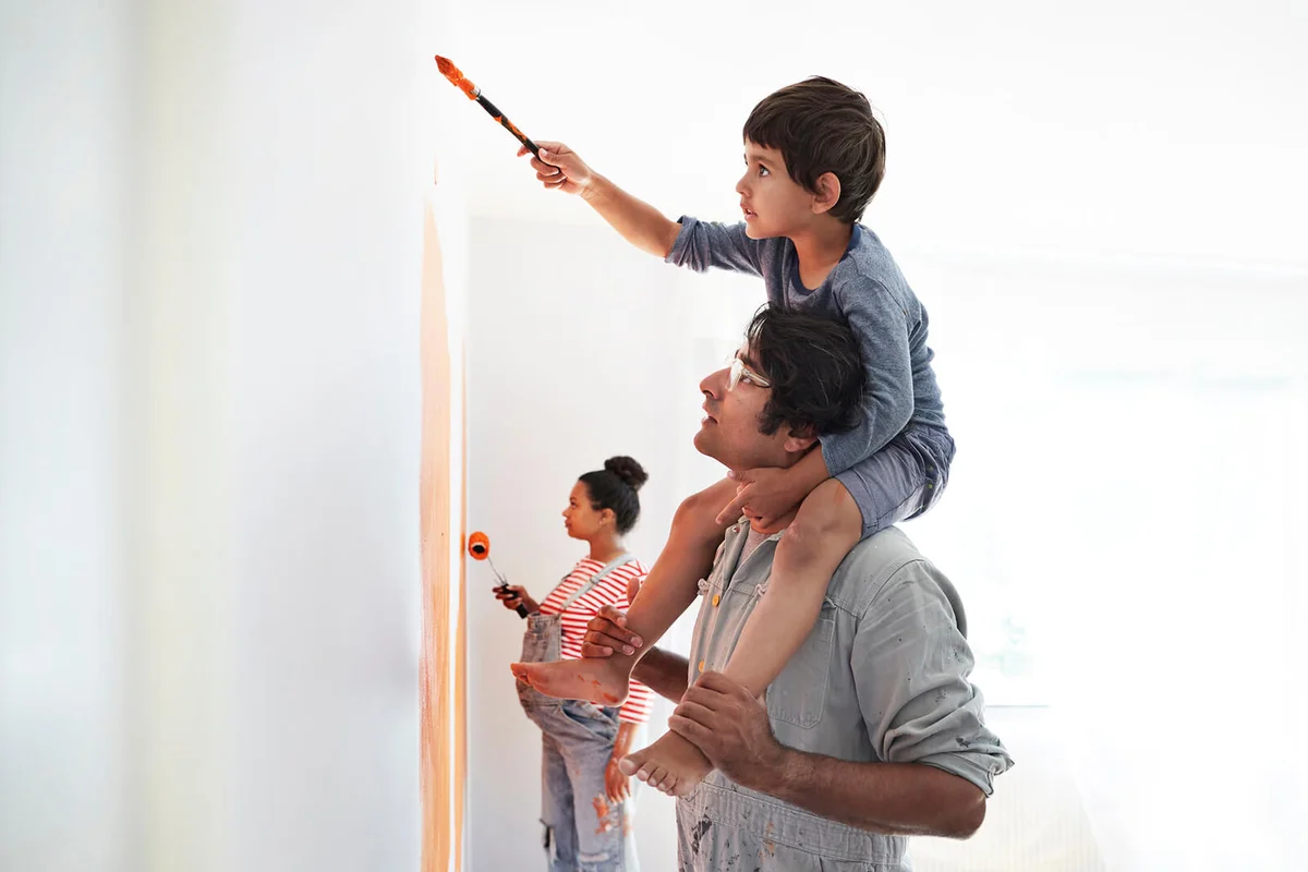 Family painting wall during home renovation