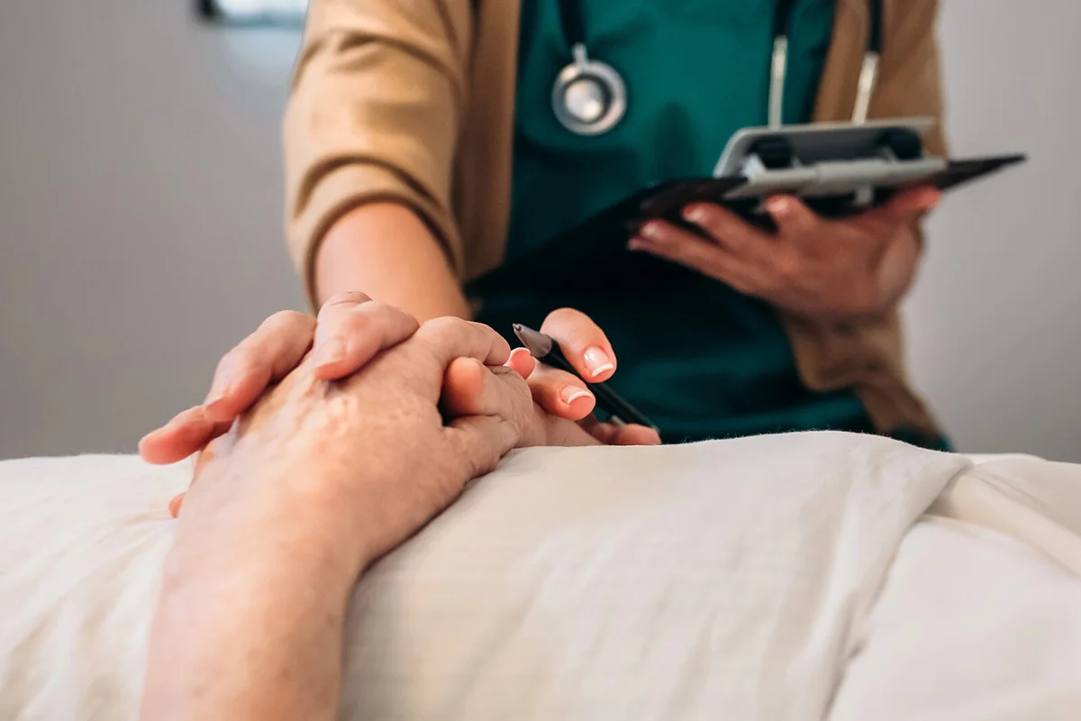 Female doctor comforting older patient