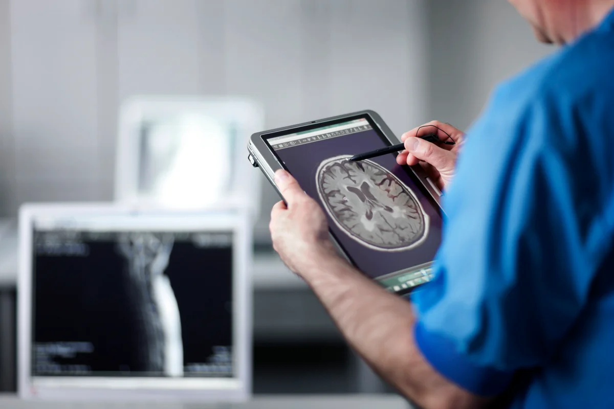 Doctor holding portable computer with MR scan