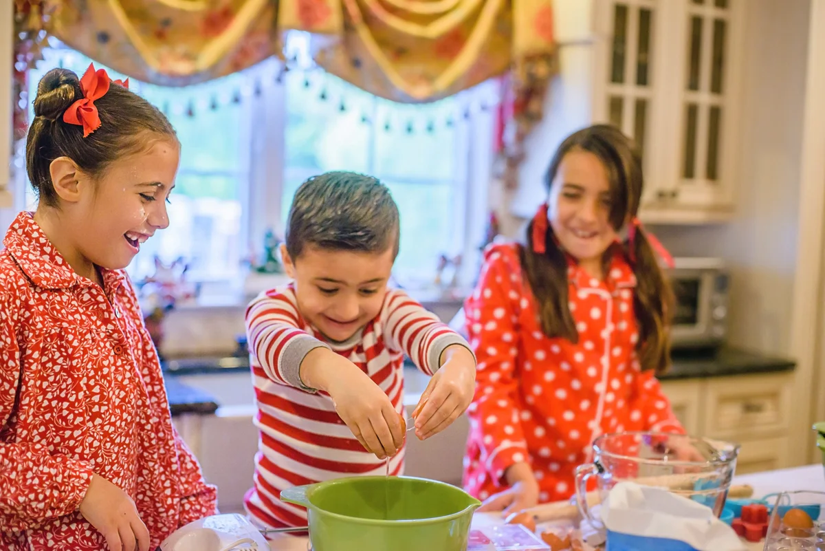 Children in kitchen wearing pijamas and making cookies