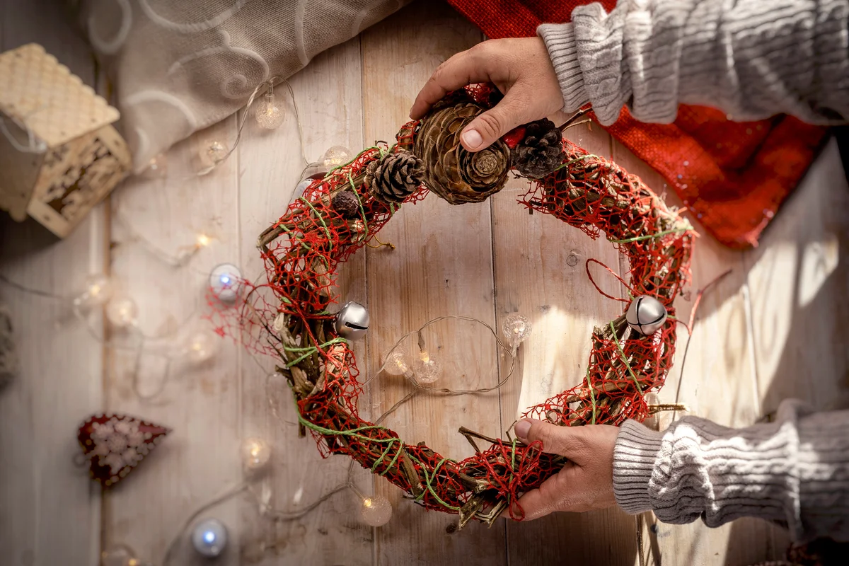 Kid hold up a decorative christmas wreath
