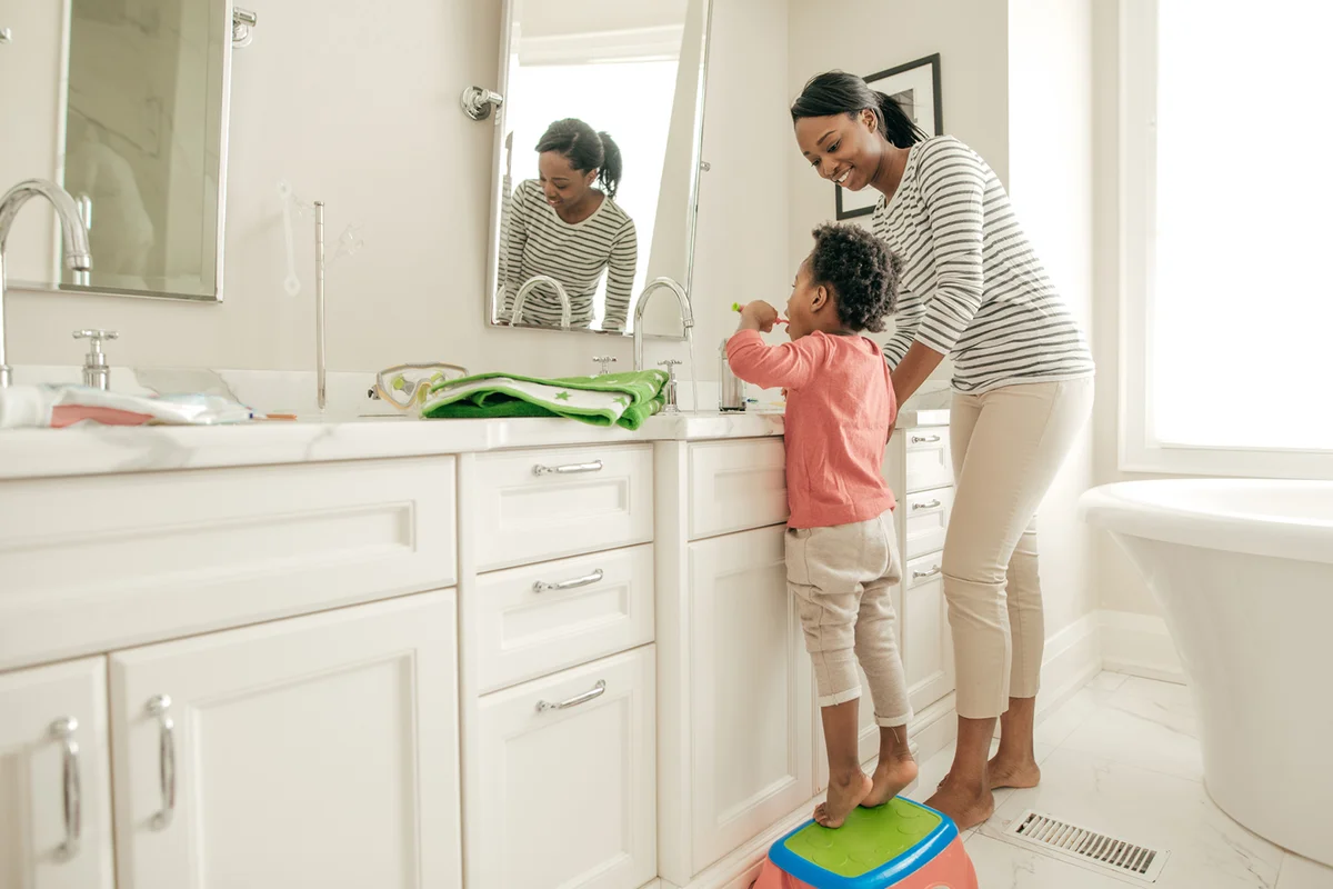 Mother and toddler brushing teeth
