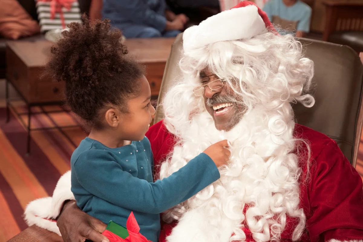 Girl pulling on Santa's beard