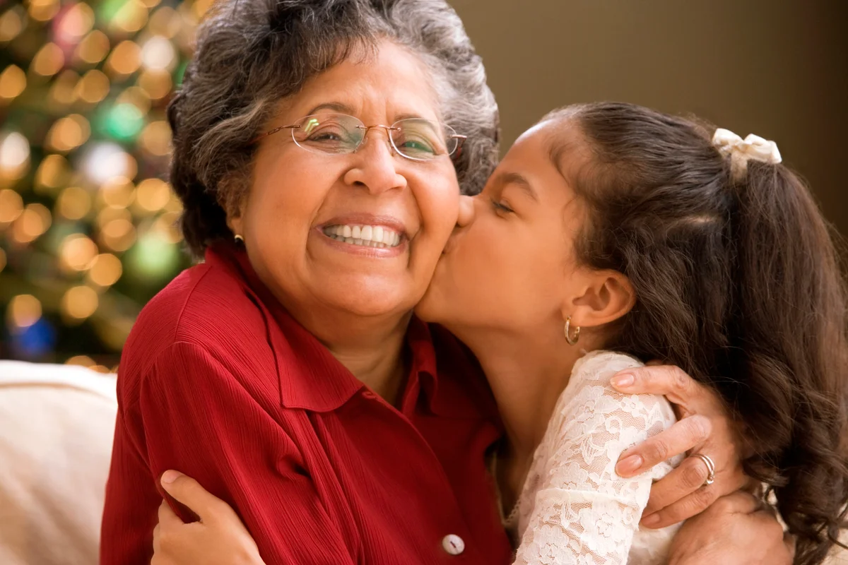 Granddaughter kissing grandmother at Christmas time