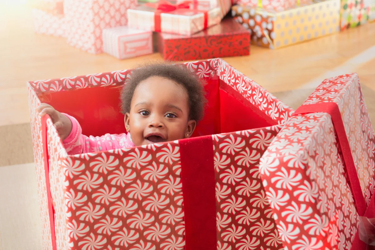 Baby girl playing in Christmas gift box