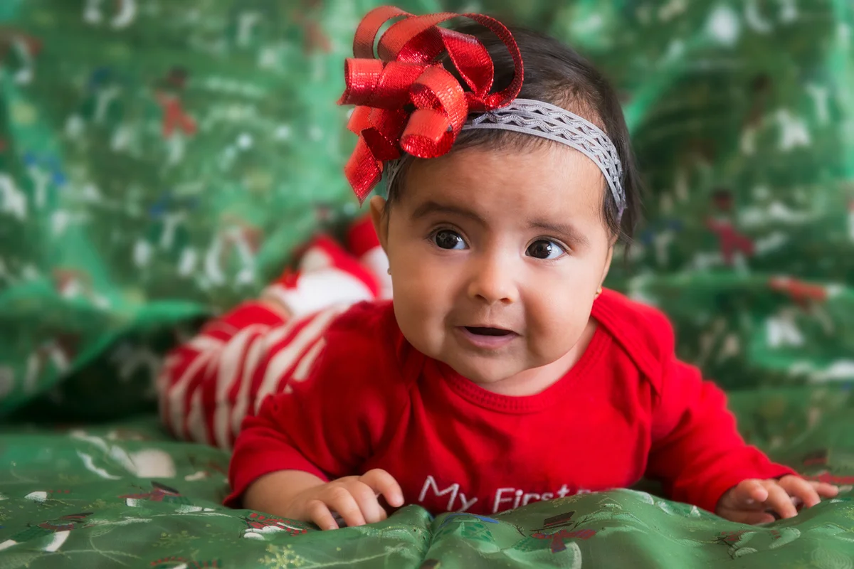 newborn baby girl wearing a Christmas pajama