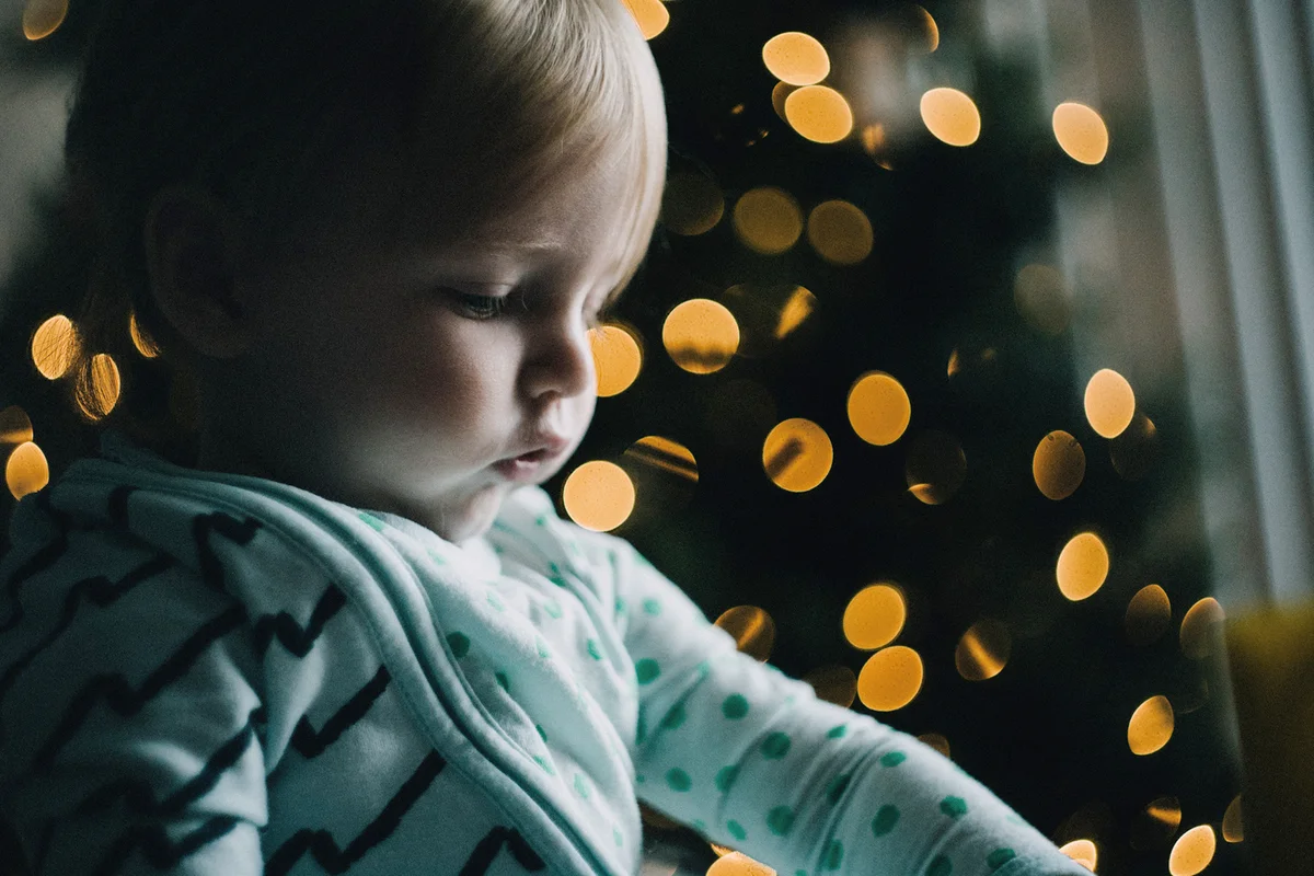 baby in front of christmas tree in the morning light