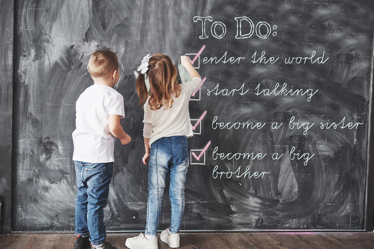 Cute little girl and boy drawing with crayon color on the wall
