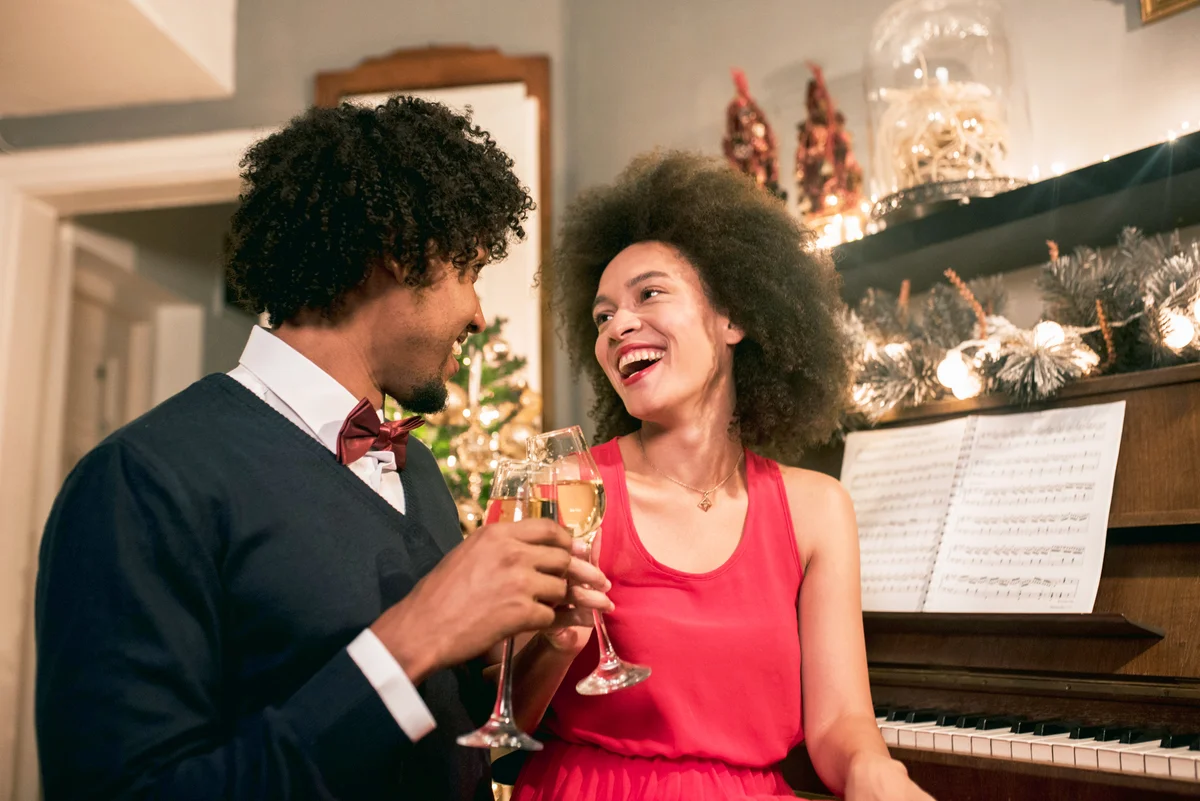 Happy couple having celebratory toast at christmas